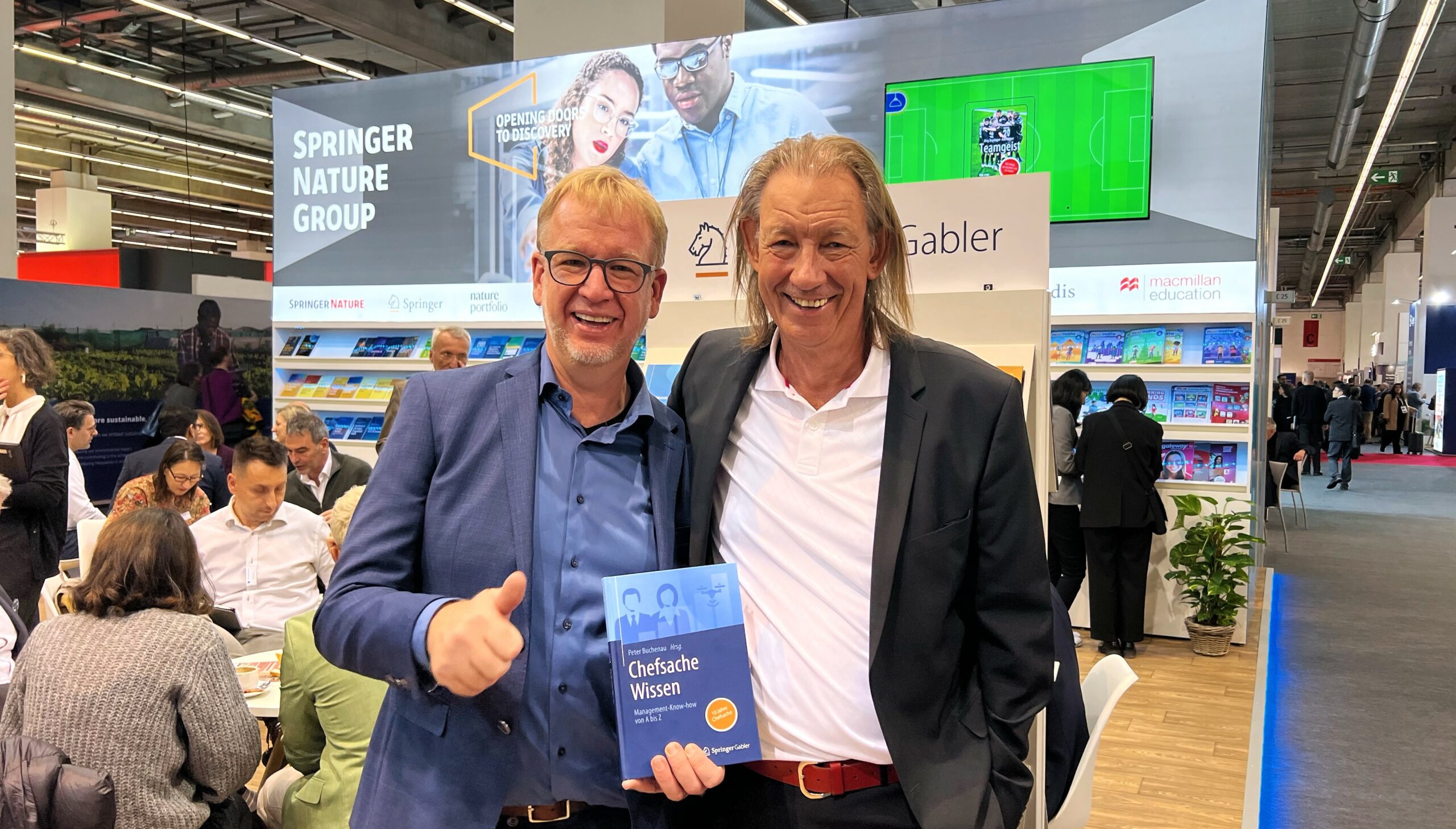 Foto von Uwe Brüggemann und Peter Buchenau auf der Frankfurter Buchmesse beim Springer Nature Stand mit Buch Chefsache Wissen